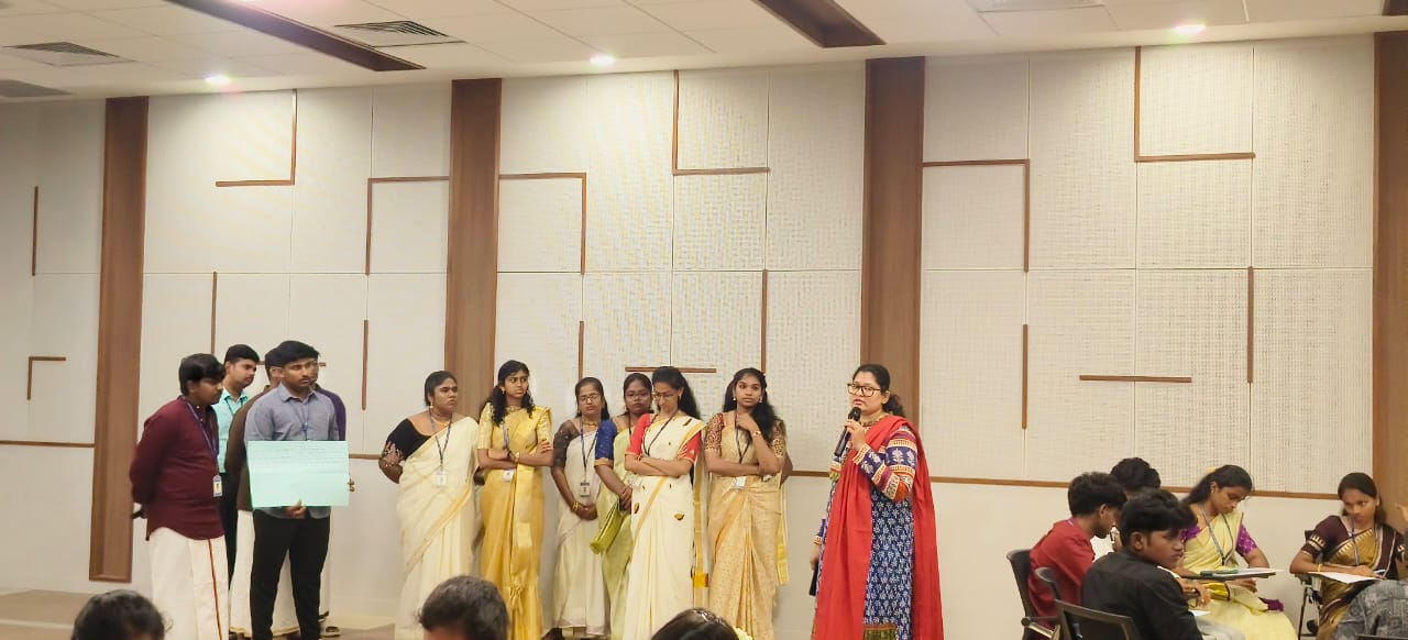 Janani Ramakrishnan leading a group activity with participants in traditional attire
